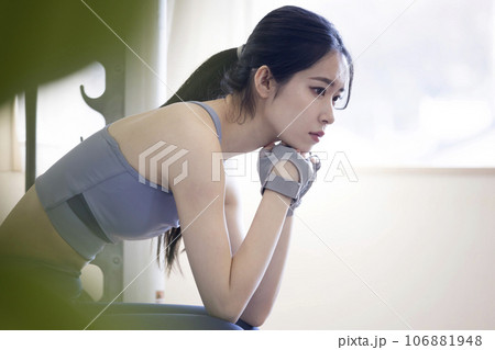フィットネスジムで休憩をする若い女性 フィットネスジムで休憩をする若い女性 106881948