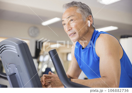 スポーツジムでエアロバイクに乗る中高年男性 スポーツジムでエアロバイクに乗る中高年男性 106882736