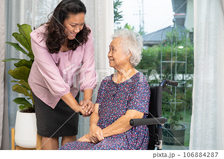 Caregiver help Asian senior woman on wheelchair with love at home. 106884287