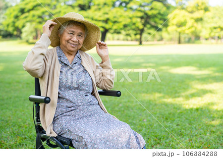 Asian senior woman sitting on wheelchair in holiday at park. 106884288