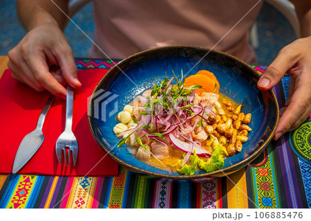 Peruvian-style ceviche plate in outdoor dining, male guest hands ready 106885476