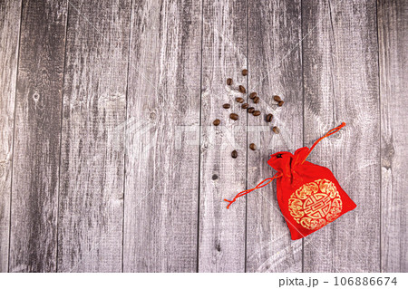Coffee beans scattered from a silk red bag on grey boards Coffee beans scattered from a silk red bag on grey boards 106886674