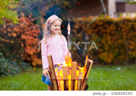 Child with smores at fire. Kids roast marshmallow. 106888585