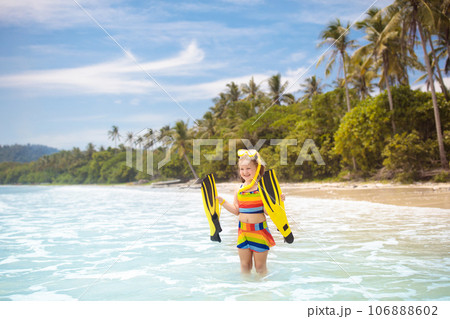 Child with swim fins snorkeling on tropical beach. Child with swim fins snorkeling on tropical beach. 106888602