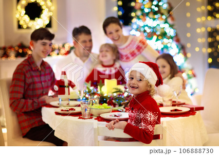 Family with kids having Christmas dinner at tree Family with kids having Christmas dinner at tree 106888730