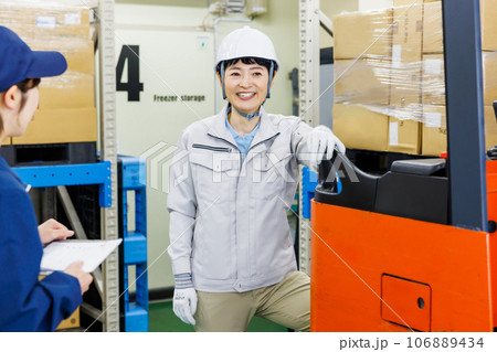 倉庫でフォークリフトを使う女性作業員 106889434