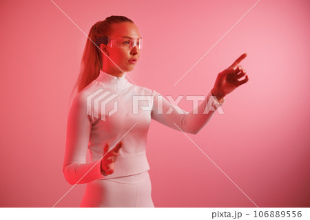 Woman in smartglasses against red neon background 106889556