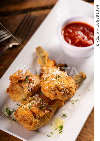 Italian fried lamb chops served with marinara sauce 106891394