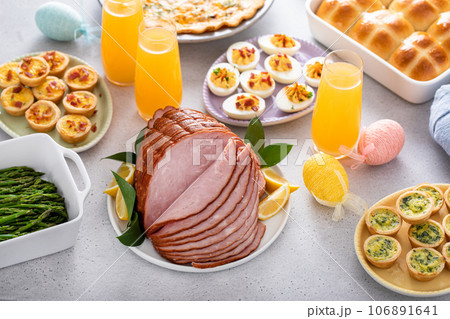 Easter brunch table with ham, quiche, hot cross buns 106891641