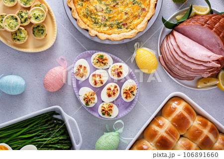 Easter brunch table with ham, quiche, hot cross buns Easter brunch table with ham, quiche, hot cross buns 106891660