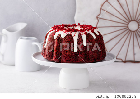 Red velvet bundt cake with cream cheese frosting and cake crumbs 106892238