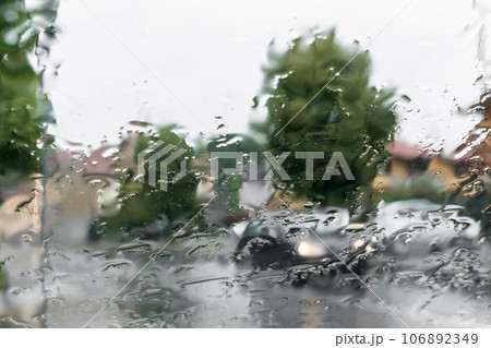 Blurred view of road through wet car window Blurred view of road through wet car window 106892349