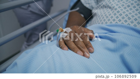 African American patient lies on gurney with venous catheter 106892509