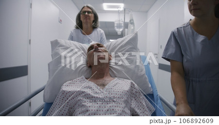 Old patient sleeps on gurney with breathing tube after operation. 106892609