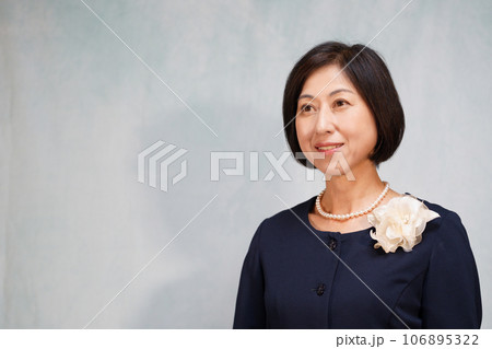 パールネックレスとコサージュを付けた笑顔の中年女性 パールネックレスとコサージュを付けた笑顔の中年女性 106895322