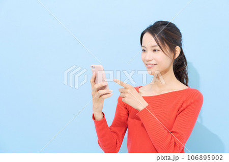 スマホを見る女性 106895902
