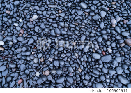 Gray pebbles as a background. Round stones on the beach. Photography for design.  106903911