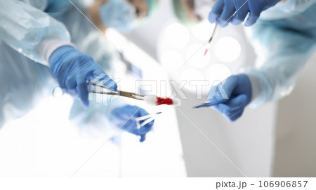 Group of doctors are holding surgical instruments over patient closeup 106906857