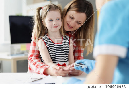 Doctor checks blood sugar level of little girl using digital glucometer at hospital Doctor checks blood sugar level of little girl using digital glucometer at hospital 106906928
