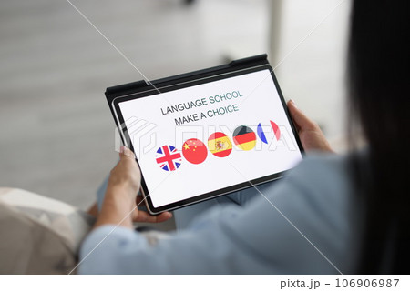 Woman holds tablet and chooses a foreign language to study 106906987