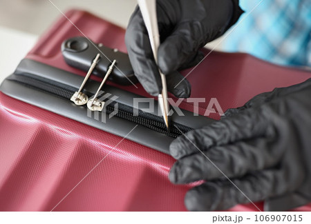 Thief with gloves tries to open suitcase with handle Thief with gloves tries to open suitcase with handle 106907015