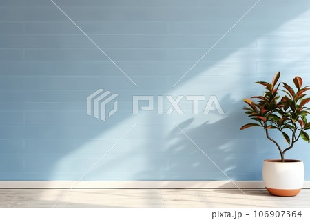 plant against a blue wall background with copy space 106907364