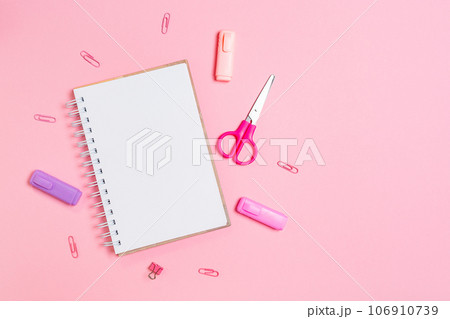 Back to school. Composition with copybook and pink office supplies on pink background. Flat lay. Mock up. Concept of education and creativity Back to school. Composition with copybook and pink office supplies on pink background. Flat lay. Mock up. Concept of education and creativity 106910739
