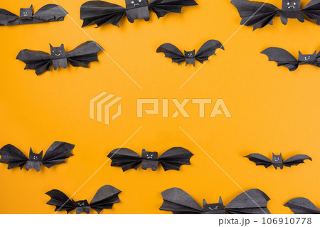 Bats made of paper are arranged on an orange background. Copy space. Flat lay. The concept of Halloween, and holiday decorations Bats made of paper are arranged on an orange background. Copy space. Flat lay. The concept of Halloween, and holiday decorations 106910778