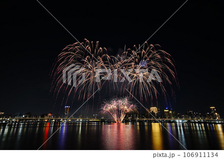 Colorful fireworks of various colors over night sky with    reflection in water   106911134
