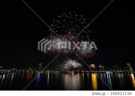 Colorful fireworks of various colors over night sky with    reflection in water   106911136