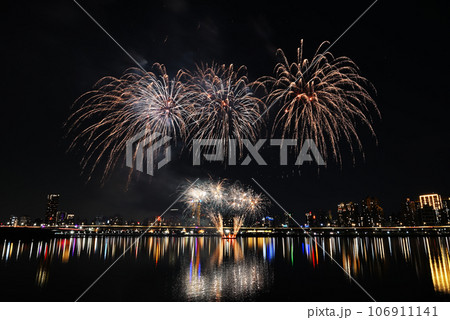 Colorful fireworks of various colors over night sky with    reflection in water   106911141