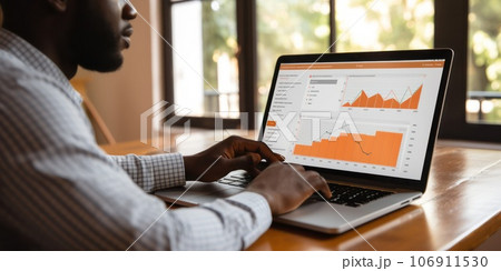 Male financial analyst in eyeglasses works in front of a laptop monitor. Male financial analyst in eyeglasses works in front of a laptop monitor. 106911530