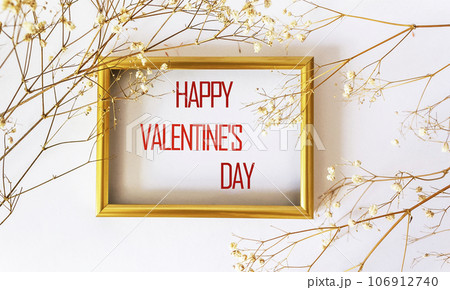 Happy Valentine's Day written on a gold frame framed with dry white flowers on a white background Happy Valentine's Day written on a gold frame framed with dry white flowers on a white background 106912740