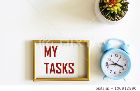 My Tasks text is written in a frame on a white background, next to an alarm clock and a cactus  106912890