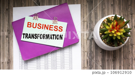 Business transformation text is written on a note that lies on a notebook and contracts  106912910