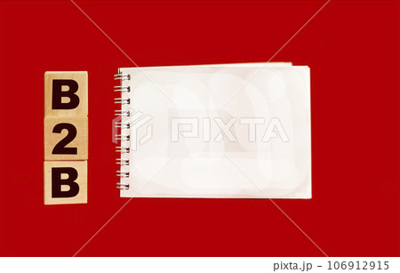 B2B, wooden cubes with B2B abbreviation and notepad for writing.B2B marketing. B2B, wooden cubes with B2B abbreviation and notepad for writing.B2B marketing. 106912915