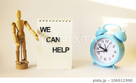 We can help, text on a notebook and a wooden doll and a clock on a white background 106912990