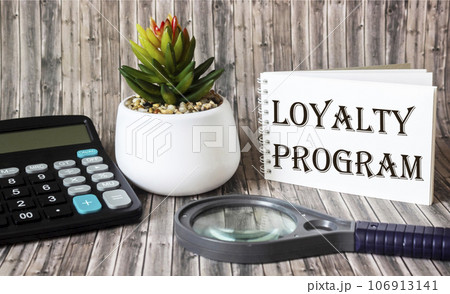 Loyalty program text on the calendar, next to a calculator, magnifier, cactus flower  106913141