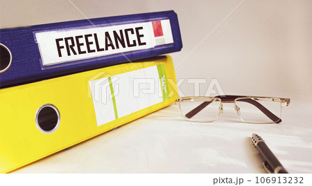 Two folders are on a white background, one with the word FREELANCE written on it. Two folders are on a white background, one with the word FREELANCE written on it. 106913232