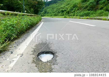 大雨で穴が空いた道路 106914435
