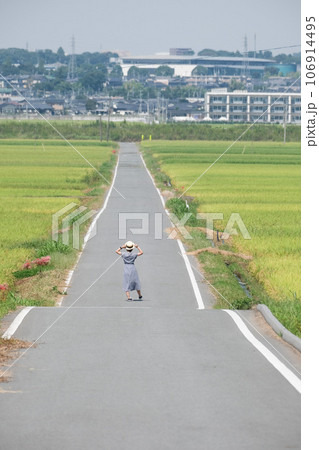 田んぼ道を歩く女性 田んぼ道を歩く女性 106914495