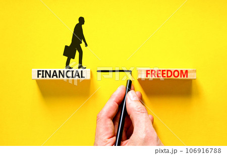 Financial freedom symbol. Concept words Financial freedom on beautiful wooden blocks. Beautiful yellow table yellow background. Businessman hand. Business financial freedom concept. Copy space. 106916788
