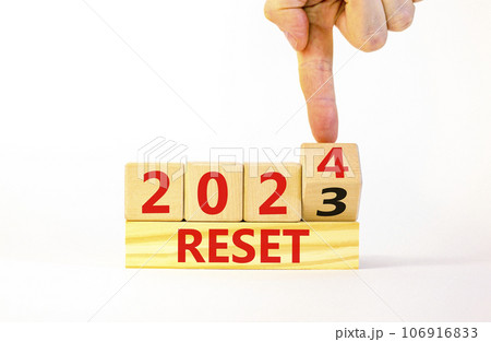 2024 reset new year symbol. Businessman turns a wooden cube and changes words Reset 2023 to Reset 2024. Beautiful white table white background, copy space. Business 2024 reset new year concept. 106916833