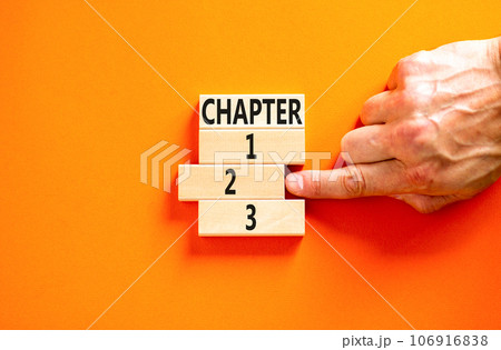 Time to chapter 2 symbol. Concept word Chapter 1 2 3 on wooden block. Businessman hand. Beautiful orange table orange background. Business planning and time to chapter 2 concept. Copy space. 106916838