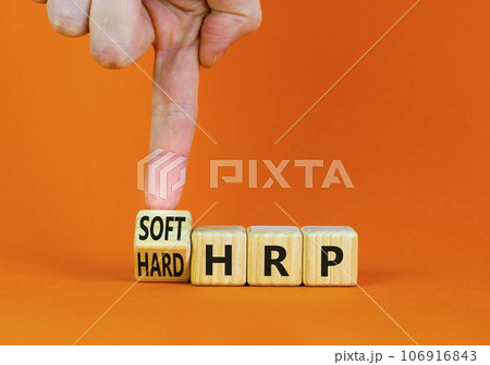 HRP, human resource planning symbol. Businessman turns a wooden cube and changes words hard HRP to soft HRP. Beautiful orange background. Business, HRP, human resource planning concept. Copy space. 106916843