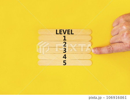 Time to level 3 symbol. Concept word Level 1 2 3 4 5 on wooden sticks. Businessman hand. Beautiful yellow table yellow background. Business planning and time to level 3 concept. Copy space. 106916861