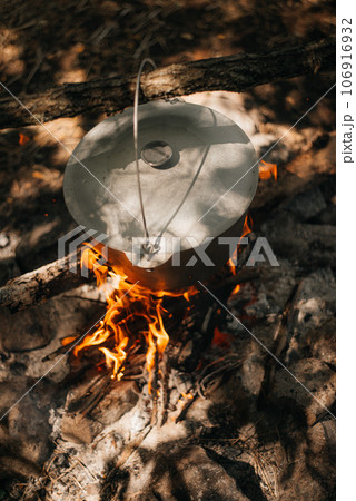 Cooking in a pot over campfire 106916932
