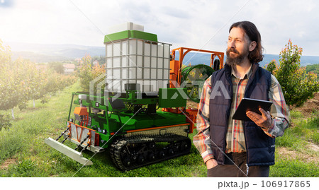 Autonomous robot sprayer works in a fruit garden.  106917865