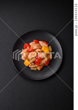 A delicious dish consisting of slices of chicken, sweet peppers and onions 106918118