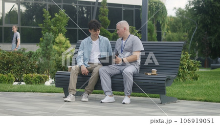 Doctor with tablet sits with patient on bench Doctor with tablet sits with patient on bench 106919051